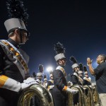 Andrew Snead ’11, assistant director of the Powhatan High School marching band, provides last-minute instruction to students before their halftime performance.