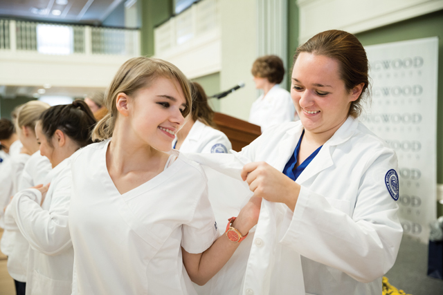 Kristen Malbone '17 (right) welcomes Lesley Piszczek '18 to the nursing profession.