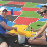 Kinesiology majors Chris Thornton ’16, of Richmond, and Samantha Byers ’16, of Toano, paint the state of Louisiana yellow on the U.S. map Longwood students created at Bacon District Elementary in Charlotte County. Courtesy of Dr. ‘Vonnie’ Colvin